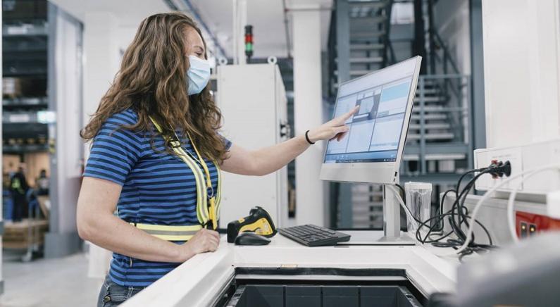 IKEA-Mitarbeitende an der Ware-zu-Person Pickstation nutzen die Swisslog SynQ Warehouse Management Software. Bild: Swisslog AG
